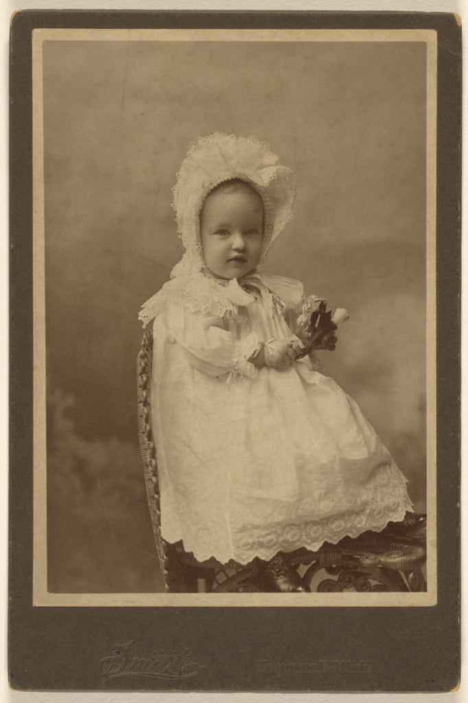 Smith:[Unidentified baby wearing a bonnet, holding a flower,,16x12